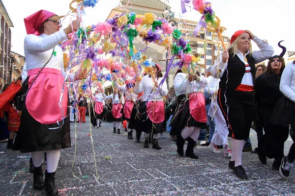 Avellino, İtalya - 23 Şubat 2020: Karnaval kostümlü insanlar Shrove Salı gününden önceki Pazar günleri boyunca şehirde dans edip geçit töreni yapıyorlar. Avellino karnavalının tipik karakterleri. Dansçılar renkli çiçek kemerlerinin altında dans ediyorlar..