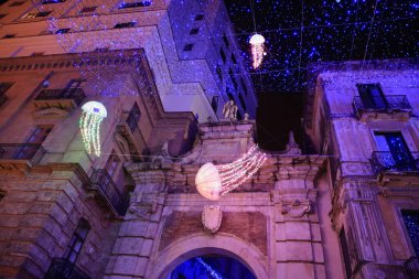 Salerno, İtalya: 06 Aralık 2023: Salerno 'nun tarihi merkezinde Noel süslemeleri. Bir denizanası denizi tarihi merkezde bir meydan yakıyor. Çeşitli boyutlarda denizanaları ve insanlar fotoğraf çeker..