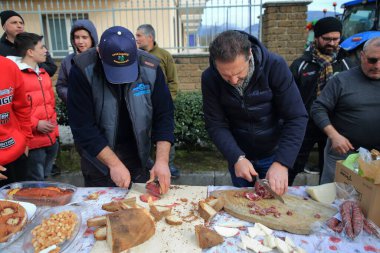 Avellino, İtalya-Şubat 07.2024: Bir grup çiftçi Avrupa Topluluğu 'nun tarım politikalarını protesto ediyor. Traktörleriyle şehrin sokaklarında yürüyorlar. Yerel ürünlerle öğle yemeği yiyorlar..