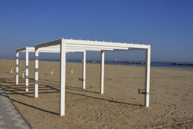 Bellaria Igea Marina, Rimini, İtalya: Ekim 01.2023: Yaz döneminden sonra kapatılan ve Paskalya 'da yeniden açılmaya hazır olan hamamların arasında sahilde yürümek.