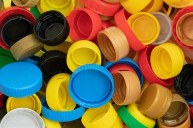 Evde sıralanmış çok renkli plastik kapaklar, geri dönüşüme hazır.