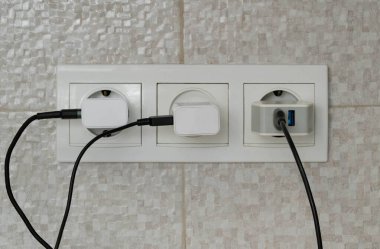 Üç elektrik prizine bağlı ağaç kablosu.
