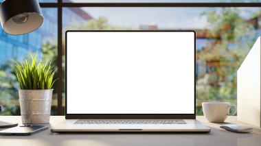 Boş çerçevesiz bir ekran modelleme şablonuna sahip bir dizüstü bilgisayar, ofis içi bir masanın üzerine yerleştiriliyor ve arka planda ofis binaları bulunan bir ön görüş sunuyor.
