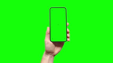 Bir adam üzerinde izleme işaretleri olan boş yeşil ekranlı akıllı bir telefon tutuyor ve uygulamanın ekranına parmağıyla dokunuyor. Bu renk tuşu ile uygulamanız için bir şablon görevi görür