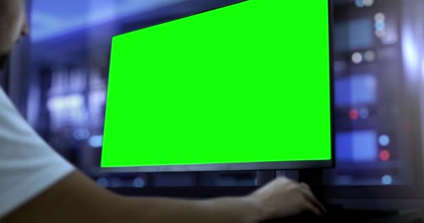一位工程师在有绿色屏幕的计算机上工作 在后台 有一个生产大厅 在技术 机械或It行业的设计设施中工作的模板 — 图库视频影像