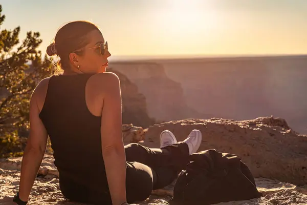 Das Mädchen Entspannt Sich Bei Sonnenuntergang Über Dem Grand Canyon Stockfoto