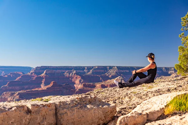 Das Mädchen Entspannt Sich Bei Sonnenuntergang Über Dem Grand Canyon Stockbild
