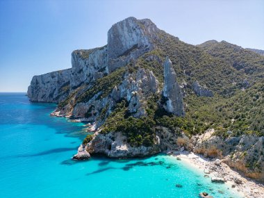 Sardinya 'nın Ogliastra bölgesinde, Orosei Körfezi' nin güneyindeki Baunei kasabasında bulunan bir gök mavisi plajı olan Cala Goloritze 'nin insansız hava aracı görüntüsü..