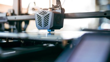 İşteki 3D yazıcının kapanışı, yazdırma başlığına ve oluşturulan detaylara odaklanıyor. Modern imalat ve prototip teknolojisinde 3D baskı teknolojisi.