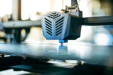 İşteki 3D yazıcının kapanışı, yazdırma başlığına ve oluşturulan detaylara odaklanıyor. Modern imalat ve prototip teknolojisinde 3D baskı teknolojisi.