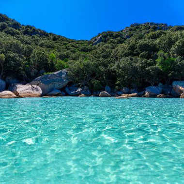 Kristal berraklığında turkuaz su ve doğayla çevrili huzurlu bir sahilde büyük, pürüzsüz kayalar. Rahatlamak ve doğayla bağ kurmak için mükemmel bir yer. Egzotik adaları anımsatan bir manzara..