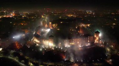 Yeni yıl arifesinde Krakow 'daki Kraliyet Wawel Kalesi' nin çarpıcı havai fişeklerle aydınlatılmış muhteşem hava manzarası. Kültür, tarih ve olaylarla ilgili materyaller için mükemmel bir geçmiş. İHA yörüngesi