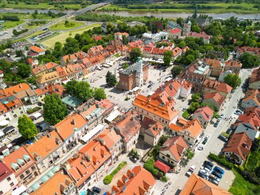 Polonya 'daki Sandomierz Eski Kasabası' nın hava panoramik manzarası. Renkli tarihi binalar, merkezi bir pazar meydanı ve güneşli bir yaz gününde etrafı yeşilliklerle çevrili kırmızı çatılar..