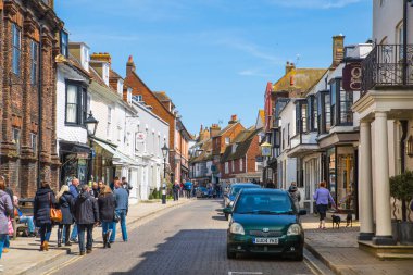 RYE, İngiltere - 1 Mayıs 2023: Eski Çavdar Mahallesi 'nin ana caddesi periyodik binalar, bir sürü insan ve araba yan tarafa park edilmiş..