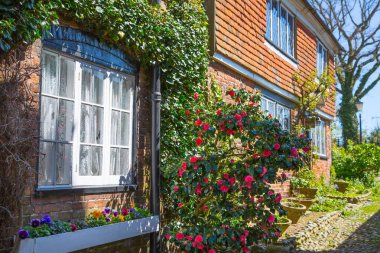 RYE, İngiltere - 1 Mayıs 2023: Eski Çavdar Mahallesi 'nin ana caddesi periyodik binalar, bir sürü insan ve araba yan tarafa park edilmiş..