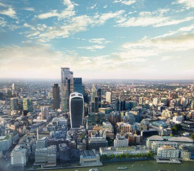 Günbatımında Londra ve Thames nehri arasında Londra şehri ve gökdelenleri olan bankacılık bölgesi yer almaktadır.