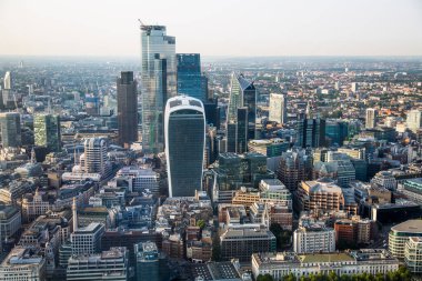 Günbatımında Londra ve Thames nehri arasında Londra şehri ve gökdelenleri olan bankacılık bölgesi yer almaktadır.