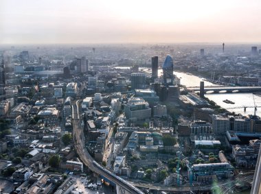 Günbatımında Londra ve Thames nehri arasında Londra şehri ve gökdelenleri olan bankacılık bölgesi yer almaktadır.