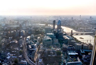 Günbatımında Londra ve Thames nehri arasında Londra şehri ve gökdelenleri olan bankacılık bölgesi yer almaktadır.