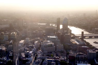 Günbatımında Londra ve Thames nehri arasında Londra şehri ve gökdelenleri olan bankacılık bölgesi yer almaktadır.