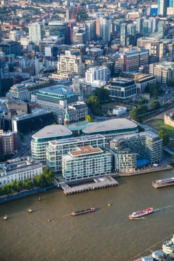 Günbatımında Londra ve Thames nehri arasında Londra şehri ve gökdelenleri olan bankacılık bölgesi yer almaktadır.