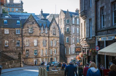 Edinburg, UK - August 23, 2022: Cockburn street with lots cafes and restaurants and walking people clipart