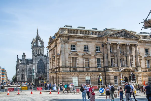 Edinburg, İngiltere - 23 Ağustos 2022: Royal Mile sokak manzaralı turistler. Edinburg 'un kalbinden geçip Edinburgh Kalesi' ni Queen 'in sarayına bağlayan