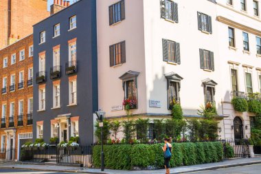 Londra, İngiltere - 9 Eylül 2023: Mayfair 'deki güzel periyodik binalar ve yolda park edilmiş lüks arabalar. Mayfair, lüks bir yaşam tarzıyla yaşamak için en zengin yerlerden biri.