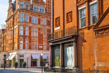 Londra, İngiltere - 9 Eylül 2023: Mayfair 'deki güzel periyodik binalar ve yolda park edilmiş lüks arabalar. Mayfair, lüks bir yaşam tarzıyla yaşamak için en zengin yerlerden biri.