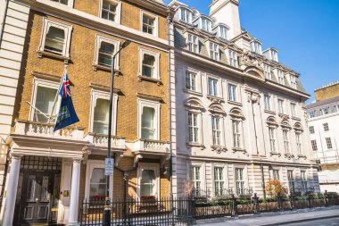 Londra, İngiltere - 9 Eylül 2023: Mayfair 'deki güzel periyodik binalar ve yolda park edilmiş lüks arabalar. Mayfair, lüks bir yaşam tarzıyla yaşamak için en zengin yerlerden biri.