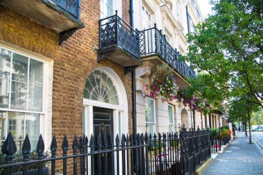 Londra, İngiltere - 9 Eylül 2023: Mayfair 'deki güzel periyodik binalar ve yolda park edilmiş lüks arabalar. Mayfair, lüks bir yaşam tarzıyla yaşamak için en zengin yerlerden biri.