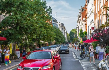 Londra, İngiltere - 9 Eylül 2023: Mayfair 'deki güzel periyodik binalar ve yolda park edilmiş lüks arabalar. Mayfair, lüks bir yaşam tarzıyla yaşamak için en zengin yerlerden biri.