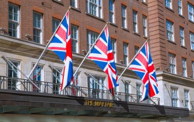 Londra, İngiltere - 9 Eylül 2023: Mayfair 'deki güzel periyodik binalar ve yolda park edilmiş lüks arabalar. Mayfair, lüks bir yaşam tarzıyla yaşamak için en zengin yerlerden biri.