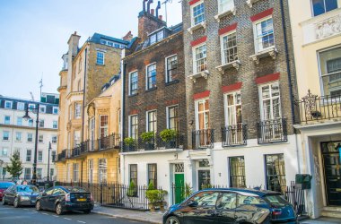 Londra, İngiltere - 9 Eylül 2023: Düzenli binalarla güzel Mayfair caddesi, Hyde Park 'a çıkıyor, lüks bir yaşam tarzıyla yaşamak için en zengin yerlerden biri.