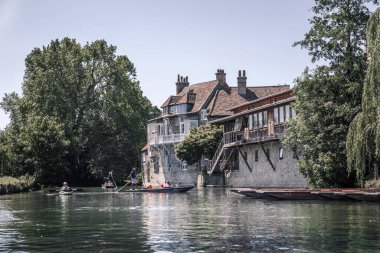 Cambridge, İngiltere - 16 Temmuz 2021: Cam nehrinin manzarası, eski üniversiteler manzarası ve tekneler 
