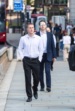 Londra, İngiltere - 7 Mayıs 2024: İş adamları Londra Köprüsü üzerinde yürüyor, otobüsler, taksiler ve arabalar yolda, 