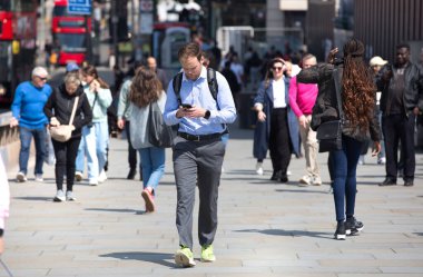 Londra, İngiltere - 7 Mayıs 2024: Londralılar Londra Köprüsü üzerinde yürüyor, otobüsler, taksiler ve arabalar yolda, 