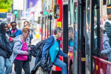 Londra, İngiltere - 7 Mayıs 2024: İnsanlar otobüs durağındaki otobüslere biniyor, Londra City 
