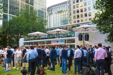 Londra, İngiltere - 30 Temmuz 2024: İnsanlar Canary Wharf 'ta çalıştıktan sonra halka açık bir kafede içki içiyorlar. 