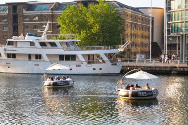 Londra, İngiltere - 30 Temmuz 2024: İnsanlar Canary Wharf 'taki piknik teknesinden gün batımının keyfini çıkarıyorlar  