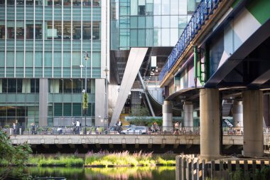 Londra, İngiltere - 30 Temmuz 2024: DLR tren istasyonu ile Canary Wharf 'taki Bank sokağı manzarası. Gün batımında gökdelenlerle şehir merkezinde iş ve bankacılık. 