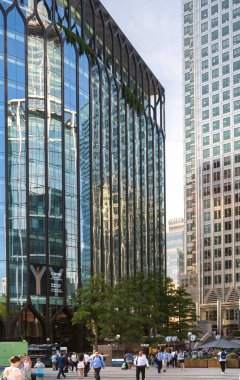 Londra, İngiltere - 30 Temmuz 2024: Canary Wharf Meydanı, metro istasyonu girişi ve yürüyen insanlar. Gün batımında gökdelenlerle şehir merkezinde iş ve bankacılık. 