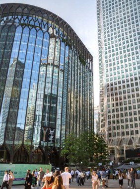 Londra, İngiltere - 30 Temmuz 2024: Canary Wharf Meydanı, metro istasyonu girişi ve yürüyen insanlar. Gün batımında gökdelenlerle şehir merkezinde iş ve bankacılık. 