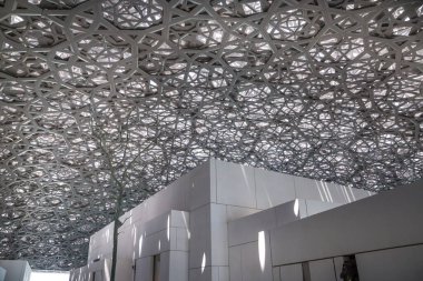 BAE, Abu Dabi - 22 Ağustos 2024: Louvre Abu Dabi avlusu Palmiye ağaçlarının gölgelerinden esinlenerek ünlü kubbe metal çatısı. 