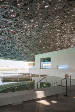 BAE, Abu Dabi - 22 Ağustos 2024: Louvre Abu Dabi avlusu Palmiye ağaçlarının gölgelerinden esinlenerek ünlü kubbe metal çatısı. 