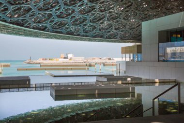 BAE, Abu Dabi - 22 Ağustos 2024: Louvre Abu Dabi avlusu Palmiye ağaçlarının gölgelerinden esinlenerek ünlü kubbe metal çatısı. 