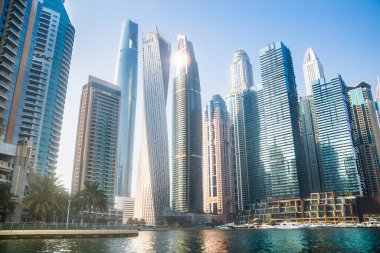 Dubai, BAE - 26 Ağustos 2024: Dubai Marina gökdelenleri gün batımında görülüyor. Tekneden panoramik görünüm