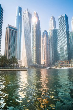 Dubai, BAE - 26 Ağustos 2024: Dubai Marina gökdelenleri gün batımında görülüyor. Tekneden panoramik görünüm