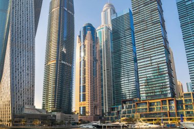 Dubai, BAE - 26 Ağustos 2024: Dubai Marina gökdelenleri gün batımında görülüyor. Tekneden panoramik görünüm