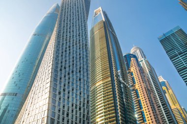 Dubai, BAE - 26 Ağustos 2024: Günbatımında Dubai Marina 'nın otelleri ve yerleşim yerleri. Tekneden panoramik görünüm